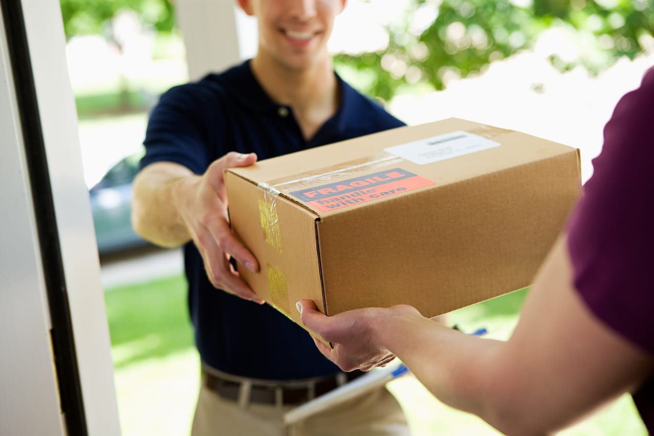 Courier handing a parcel to a customer at the door